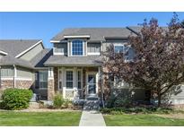 Attractive two-story townhome with stone accents and landscaped front yard at 4727 Raven Run, Broomfield, CO 80023