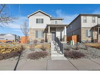 Two-story house with gray siding, stone accents, and a landscaped front yard at 6792 Longpark Dr, Parker, CO 80138