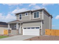 Charming two-story home with a two car garage, landscaped yard, and inviting front porch at 9456 Yampa Ct, Commerce City, CO 80022