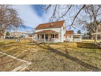 Charming two-story home with a quaint front porch and red shutters, perfect curb appeal at 5300 Balsam St, Arvada, CO 80002