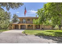 Charming two-story home with brick facade, balcony, spacious driveway, and attached two-car garage at 12196 W Belleview Dr, Littleton, CO 80127