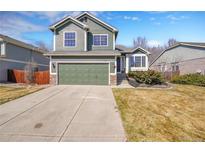 Charming two-story home boasts a well-manicured lawn, complemented by a green two-car garage and stone accents at 5051 Yates Cir, Broomfield, CO 80020