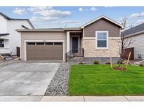Charming single-Gathering home showcasing stone accents, a two-car garage, and a well-manicured lawn at 19110 E 96Th Pl, Commerce City, CO 80022