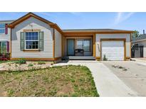 Charming single-story home with a welcoming front porch and well-maintained landscaping at 15627 E 51St Dr, Denver, CO 80239