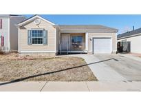 Charming single-story home with a front yard, a small porch, an attached garage, and light beige siding at 15627 E 51St Dr, Denver, CO 80239