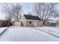 Ranch style home with snow covered yard and attached garage at 2545 S Julian St, Denver, CO 80219