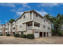 Three-story condo with siding and brick, featuring garage parking and front patio at 4947 Noble Park Pl, Boulder, CO 80301