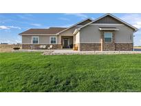 A charming single-Gathering home features a well-manicured lawn and a stone-accented facade at 16482 Ledyard S Rd, Platteville, CO 80651