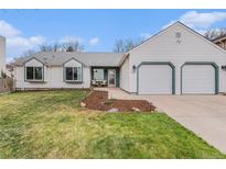 Charming home with a two-car garage, well-kept lawn, and a cozy seating area near the front door at 5408 E Briarwood Cir, Centennial, CO 80122
