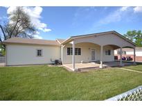Exterior shot of backyard with covered patio and lawn at 2685 W Asbury Ave, Denver, CO 80219