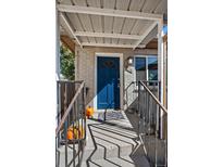Charming home's entry with blue door, stylish accents, and covered porch provides a warm welcome at 828 Mariposa St, Denver, CO 80204
