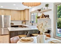 Bright kitchen boasts light wood cabinets, stainless steel appliances, and stylish decor, complemented by natural light at 10016 Teton Ct, Lone Tree, CO 80124