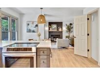 Open-concept living area with a stylish kitchen island, cozy fireplace, and comfortable seating at 10016 Teton Ct, Lone Tree, CO 80124