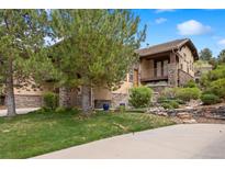 Beautiful exterior of a two-story home with stone accents, balcony, and landscaped front yard at 4364 Chateau Ridge Ln, Castle Rock, CO 80108