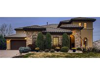Stunning stone home featuring a tile roof, landscaped yard, and charming curb appeal at 9435 Winding Hill Way, Lone Tree, CO 80124