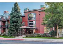 Elegant red brick building with architectural details and lush landscaping at 300 Hudson St # 202, Denver, CO 80220