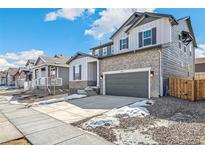 Charming two-story home with a two-car garage, stone accents, and a well-maintained front yard at 13382 E 110Th Way, Commerce City, CO 80022
