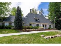 Charming home featuring manicured lawn, mature trees, and an inviting gray roof at 1512 Cottonwood Ln, Greenwood Village, CO 80121