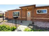 Charming single-story brick home with a cozy covered entry and well-maintained front yard at 1560 Pueblo Ct, Thornton, CO 80229