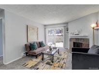 Bright living room with fireplace and sliding glass door leading to patio at 14602 E 2Nd Ave # 100C, Aurora, CO 80011