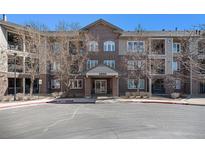 Attractive brick condo building with covered entrance and well-maintained landscaping and parking at 2896 W Riverwalk Cir # A214, Littleton, CO 80123