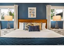 Comfortable bedroom featuring wood headboard, accent pillows, and matching bedside lamps at 7256 S Broadway, Centennial, CO 80122