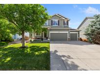Charming two-story home features a three car garage, lush lawn, and a mature shade tree at 139 N Prairie Falcon Pkwy, Brighton, CO 80601