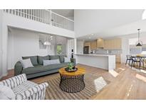 Bright living room showcasing the open layout, modern kitchen, and a comfortable seating area at 22935 E River Chase Way, Parker, CO 80138
