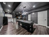 Finished basement featuring a pool table, bar, and dark modern aesthetic with recessed lighting throughout at 14589 Hagus Pl, Parker, CO 80134