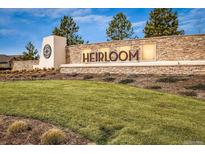 Stone monument sign for Heirloom community surrounded by a well manicured lawn and professional landscaping at 14589 Hagus Pl, Parker, CO 80134