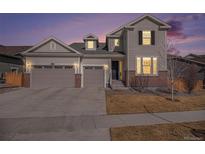 Charming two-story home with a three-car garage, brick accents, and well-maintained landscaping at 16195 Red Bud Loop, Parker, CO 80134