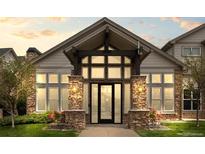 Elegant building entrance with stone pillars, ample windows, and craftsman style architectural elements at 7212 S Blackhawk St # 1-103, Englewood, CO 80112