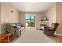 Comfortable living room with cozy seating, fireplace, and sliding glass doors to the outdoor at 7212 S Blackhawk St # 1-103, Englewood, CO 80112