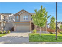 Charming two-story home with a well-manicured lawn, cozy front porch, and attached two-car garage at 15955 E Otero Cir, Centennial, CO 80112