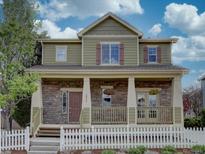 Charming two-story home with stone accents, inviting porch, and well-manicured front yard at 5072 Meadow Mountain Dr, Broomfield, CO 80023