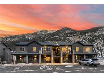 Modern townhome exterior featuring stone accents, private balconies, and stunning mountain views at sunset at 2152 Bighorn Rd # 203, Georgetown, CO 80444