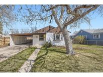 Charming single-story home with a covered carport and a well-maintained lawn, enhanced by a mature tree at 1280 S Quitman St, Denver, CO 80219
