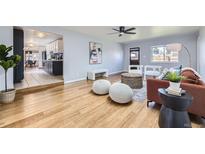 Bright living room with modern decor, wood floors, and an open layout leading to the kitchen at 1280 S Quitman St, Denver, CO 80219