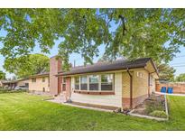 Charming brick home featuring well-maintained lawn and mature trees at 555 W Mansfield Ave, Englewood, CO 80110