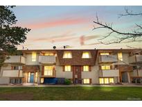 Inviting townhouse exterior with balconies, dormer windows and mature trees at sunset at 10211 Ura Ln # 1-202, Thornton, CO 80260