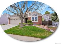 Charming brick home featuring a well-maintained front yard and a large arched window at 5231 S Cody St, Littleton, CO 80123