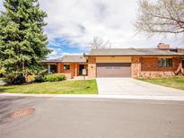 Charming single-story brick home with a two-car garage and well-maintained front lawn and mature trees at 2615 Oak Dr # 5, Lakewood, CO 80215