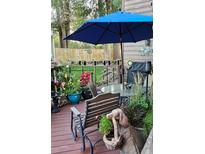 Relaxing deck area featuring elegant garden decor, comfortable seating, and a blue umbrella at 6504 Ralston Rd # A, Arvada, CO 80002