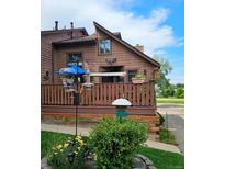 Charming multi-level house with a deck, brown siding and attractive landscaping at 6504 Ralston Rd # A, Arvada, CO 80002