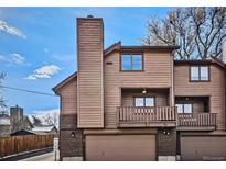 Two-story townhouse with wood siding, brick accents, and a small balcony above the garage at 6504 Ralston Rd # A, Arvada, CO 80002