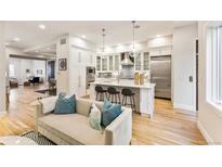 Open concept kitchen with white cabinets, island, and stainless steel appliances at 126 Garfield St, Denver, CO 80206