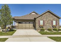Charming single-Gathering home with a well-manicured lawn, beautiful stone facade, and attached two-car garage at 16459 W 86Th Pl # B, Arvada, CO 80007