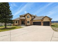 Inviting home with brick accents, three-car garage, and ample driveway space on a well-manicured lawn at 937 Caribou Dr, Monument, CO 80132