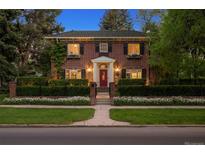 Charming two-story brick home featuring a well-manicured lawn, flower boxes and a red front door at 6300 E 17Th Avenue Pkwy, Denver, CO 80220