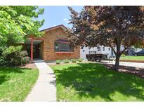 Charming brick home featuring a well-maintained lawn and a cozy front porch entry at 4720 S Grant St, Englewood, CO 80113